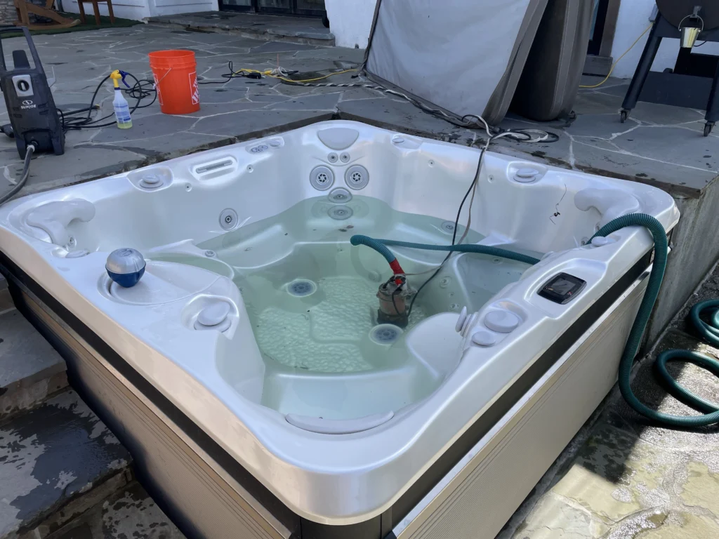 A hot tub with a hose attached to it.