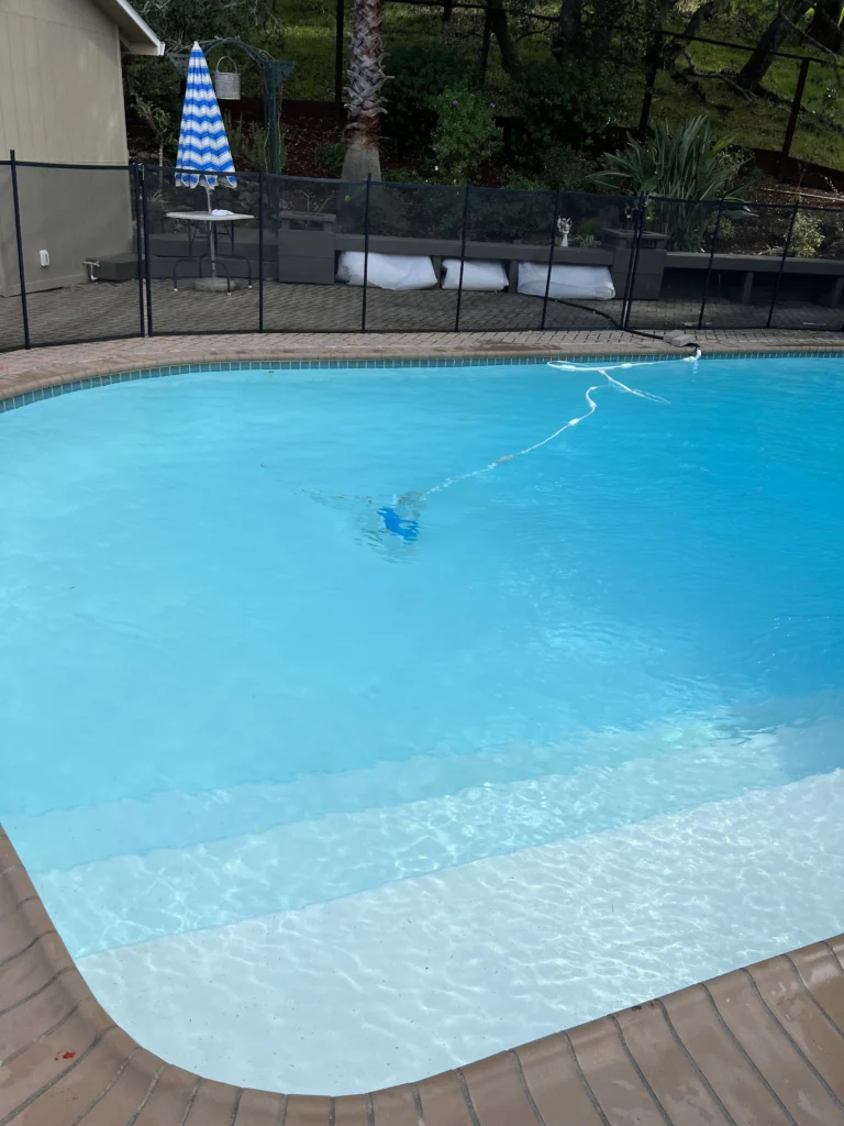 A swimming pool contractors in a backyard with a fence.