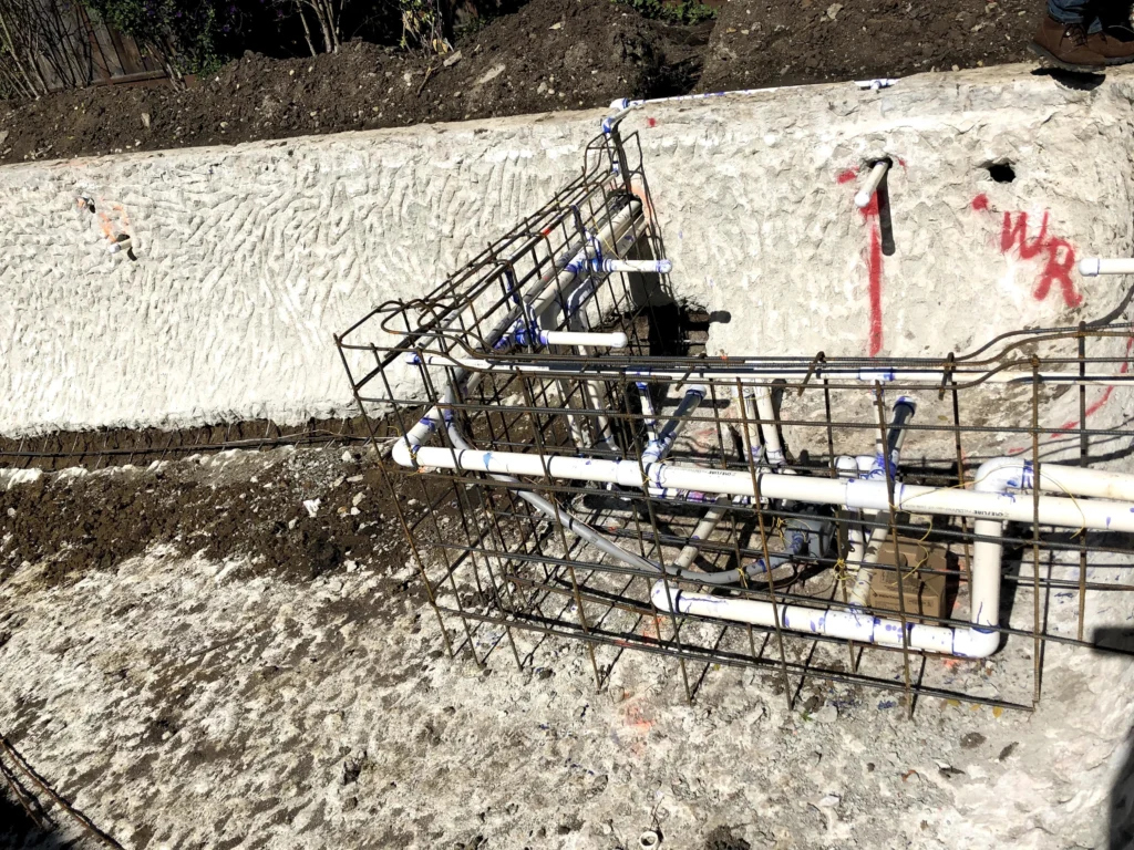 A construction site with pipes and wires in the ground.