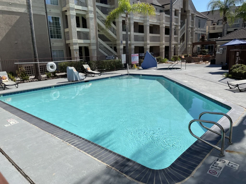 A swimming pool in front of an apartment complex.